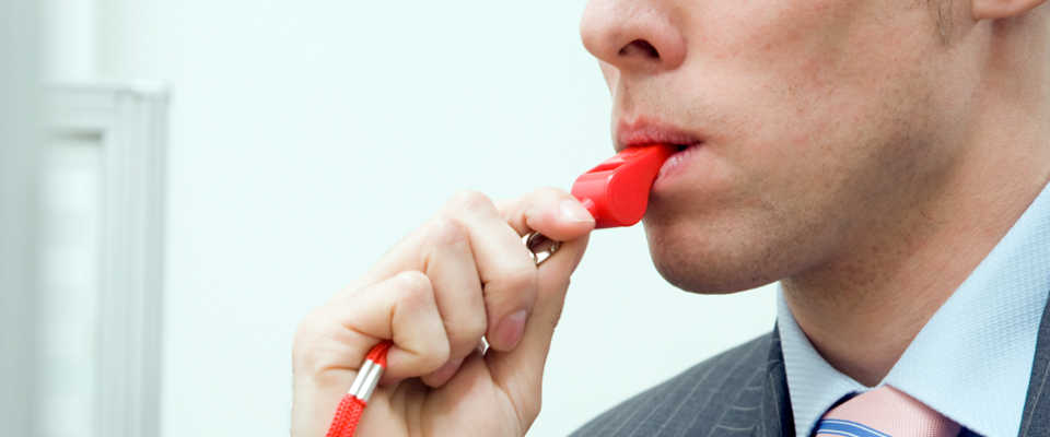 Man blowing a red whistle