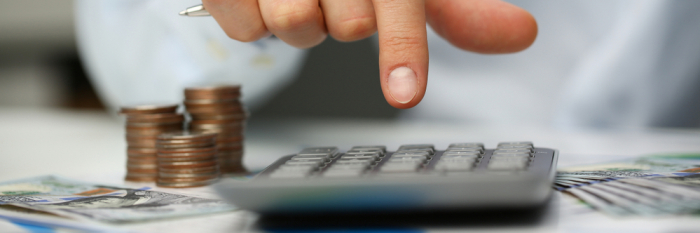 Closeup view of a person typing on a calculator